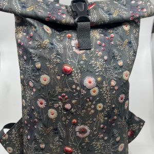 Rolovací batoh květiny na šedém podkladu.