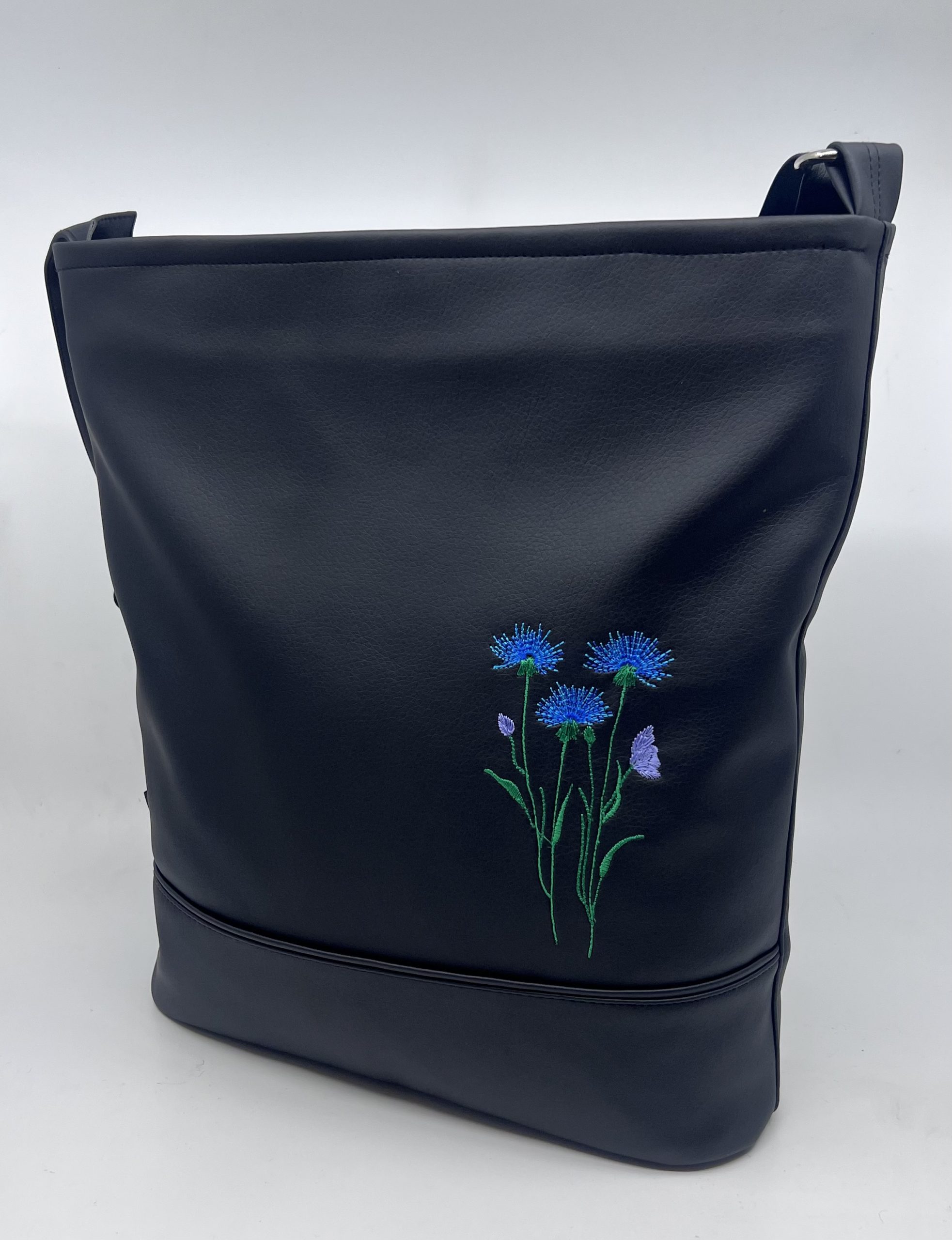 Crossbody kabelka s výšivkou chrpy.